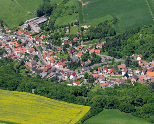 Luftbild von Gonna mit der St. Margarethen-Kirche, der Gonnaer Hauptstraße und dem Hohlweg am Südharz aus Richtung Süden.